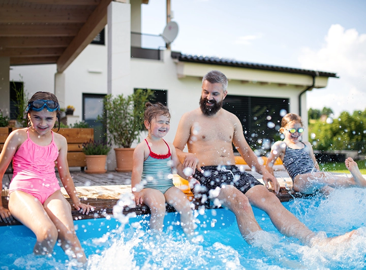 Family playing by a swimming pool protected with pool lining